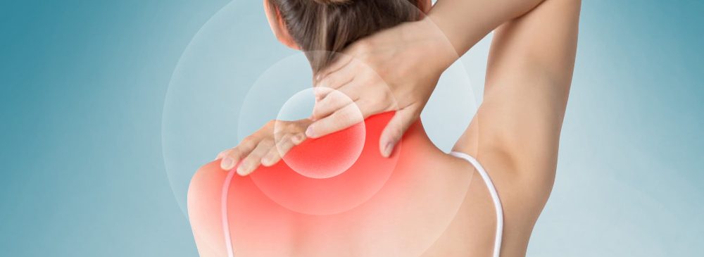 Donna con cervicalgia che tocca la zona dolorante del collo e delle spalle