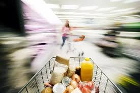 Carrello della spesa in movimento in un supermercato – sovraccarico visivo che provoca vertigini nei supermercati